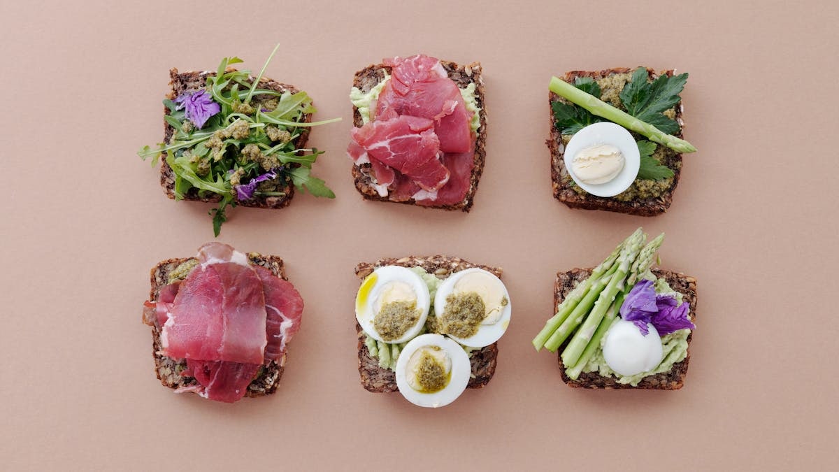 A top view of gourmet sandwiches with fresh ingredients presented in a flat lay style.